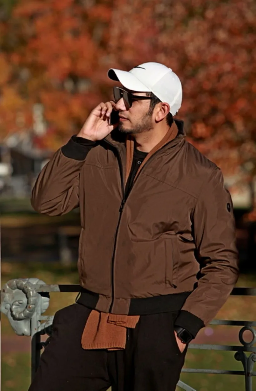 Candid outdoor portrait of a man on the phone in front of autumn foliage