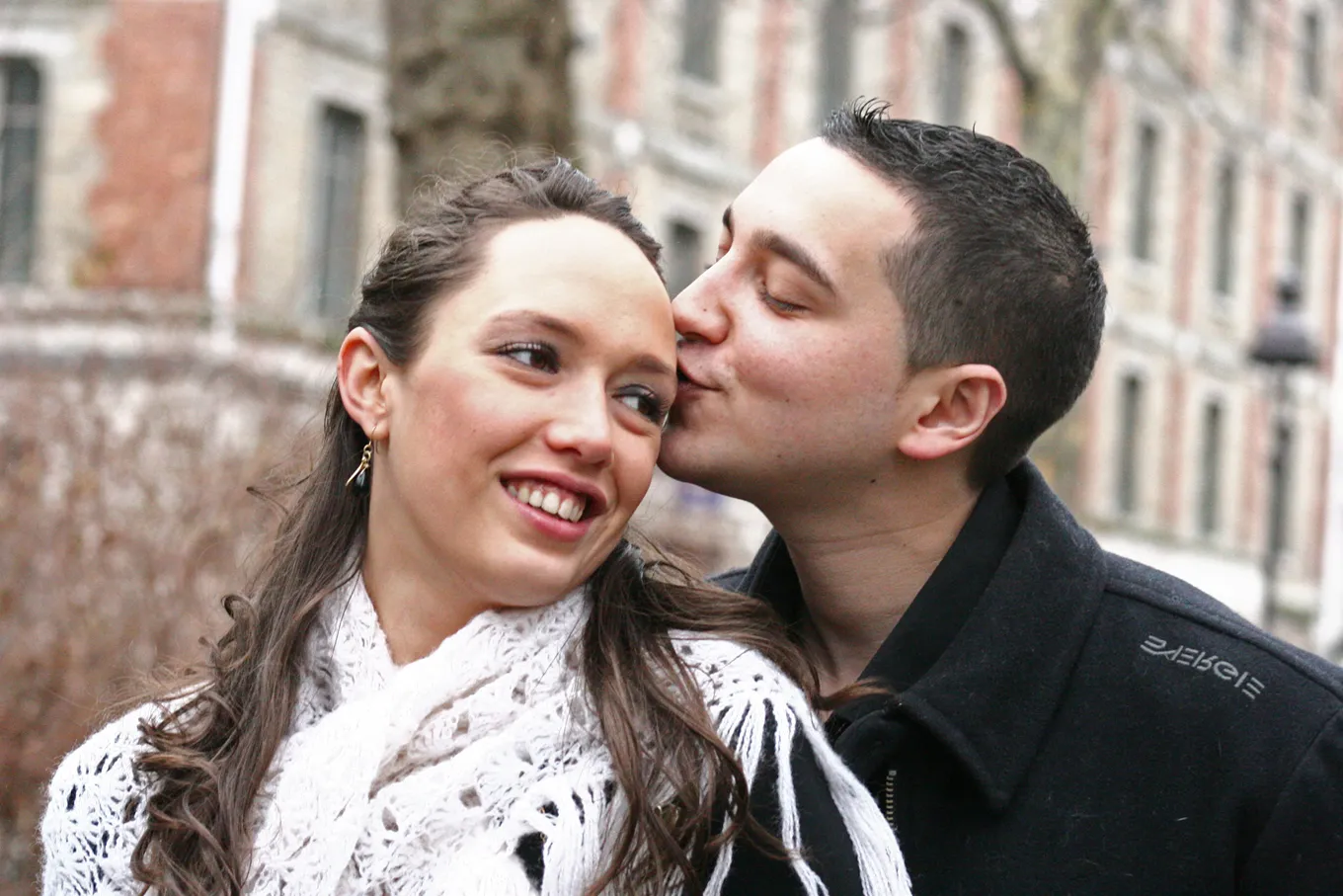 Couple sharing a candid kiss on a city street