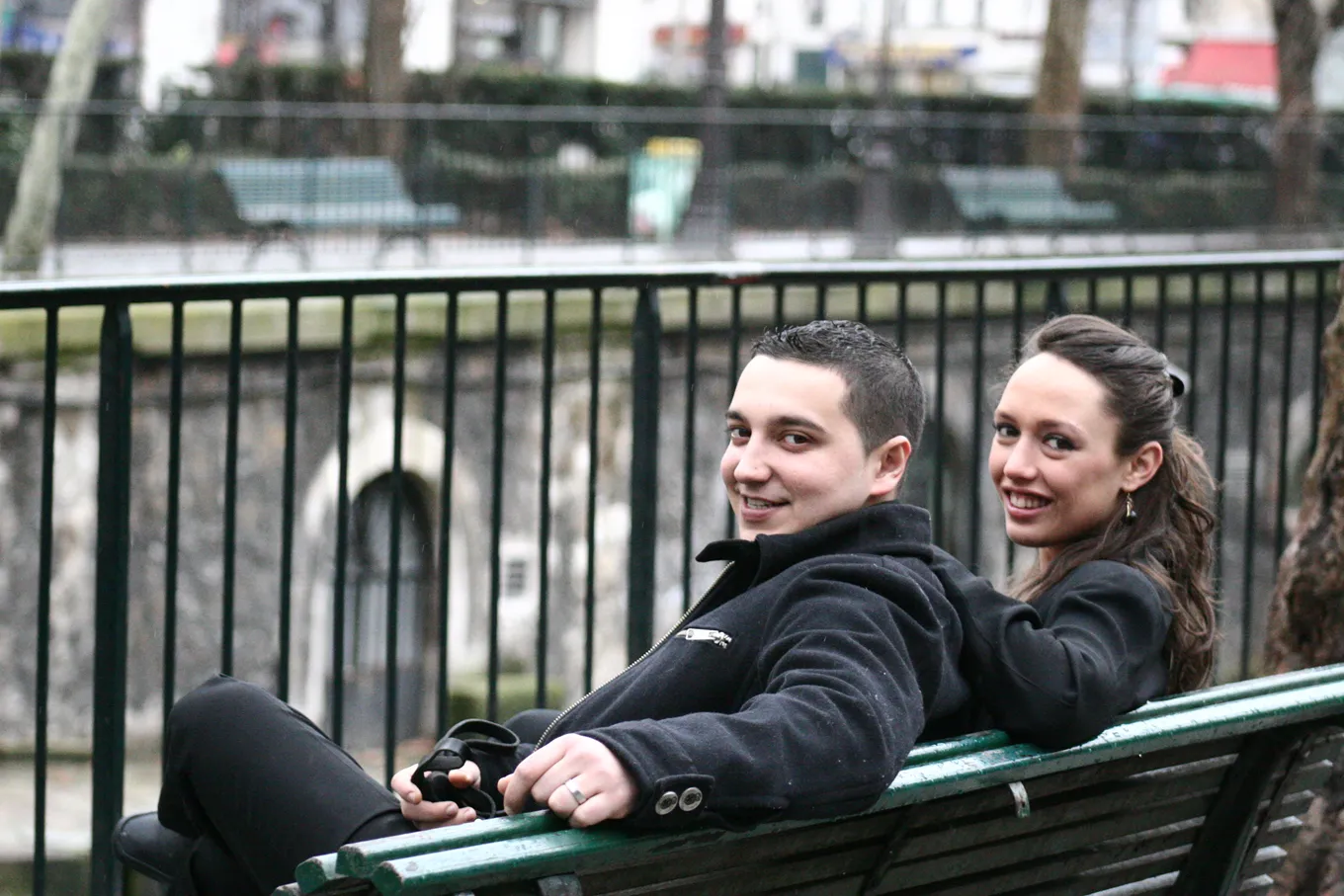 Couple laughing together on a waterfront bench