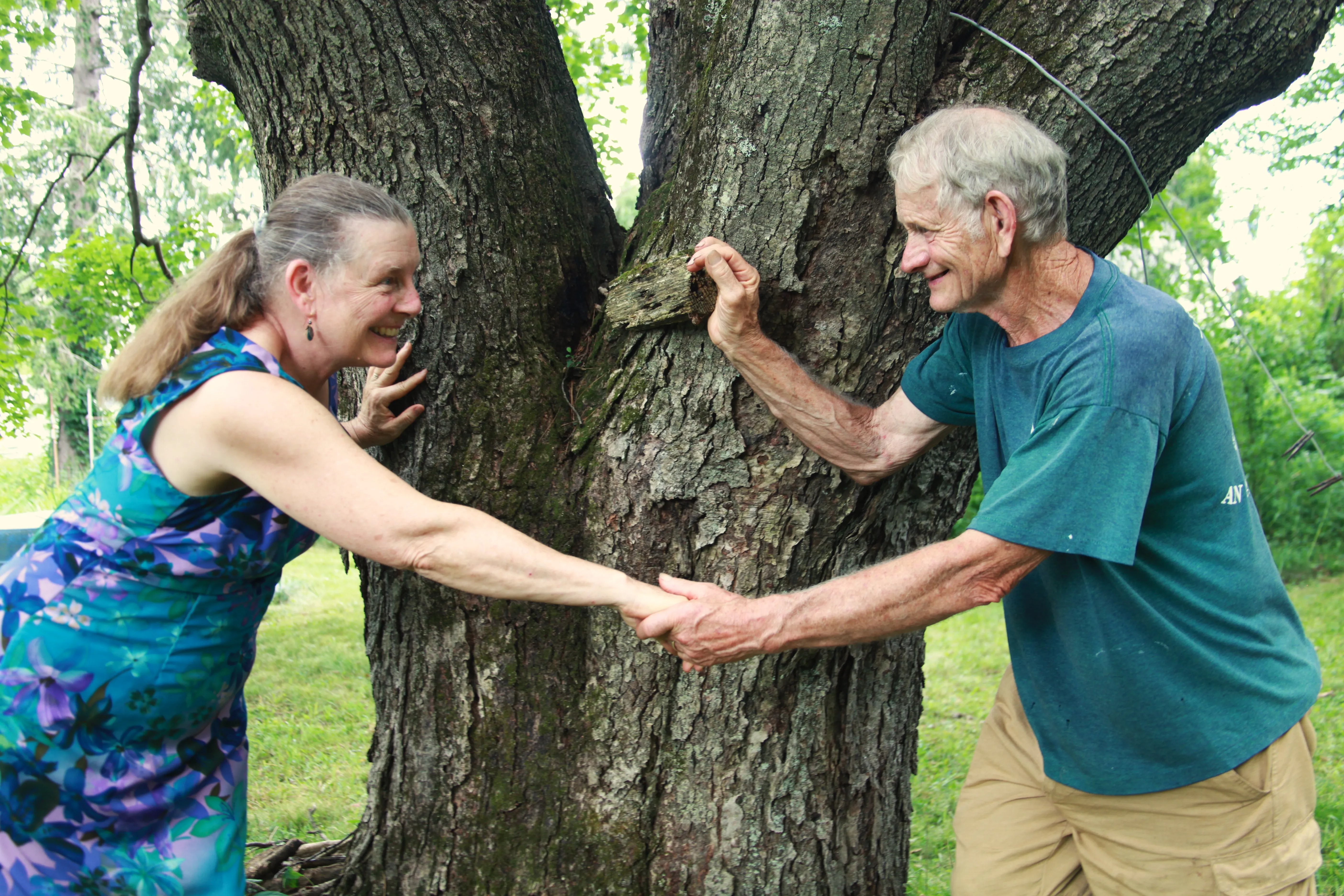 Older couple dancing together beneath a tree